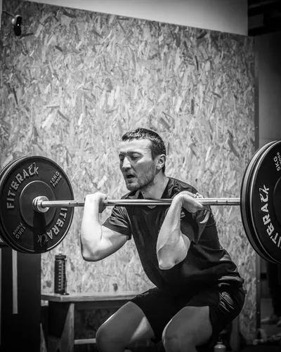 Un homme soulevant une haltère dans un exercice pour biceps