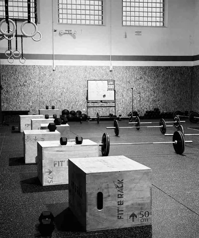 Une femme prépare une barre olympique dans la salle de functional fitness Mazamet